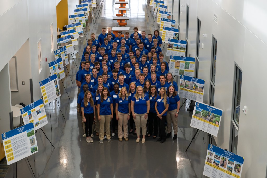 Large group of students with poster presentations